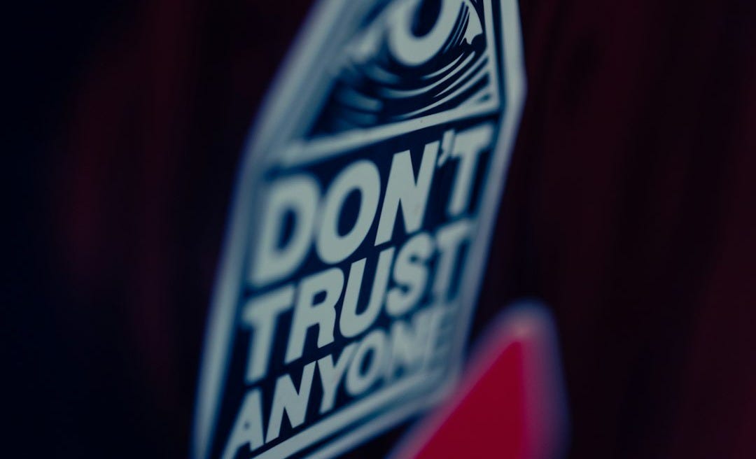 a close up of a don't trust anyone sticker