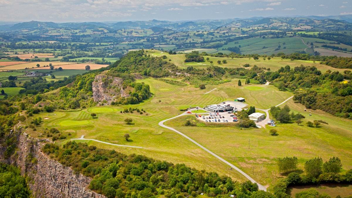 Aerial view of a clifftop golf course with fairways and greens visible, surrounded by rolling hills and farmland. Aerial view of a clifftop golf course with fairways and greens visible, surrounded by rolling hills and farmland.