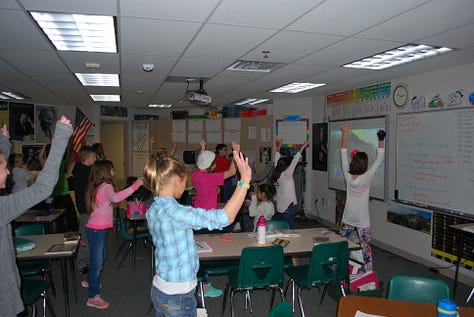 Students working on various projects throughout a classroom. 