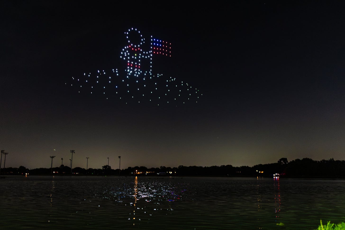 Drones portraying an astronaut with a flag in the sky above Andrew Brown Park East Drones portraying an astronaut with a flag in the sky above Andrew Brown Park East