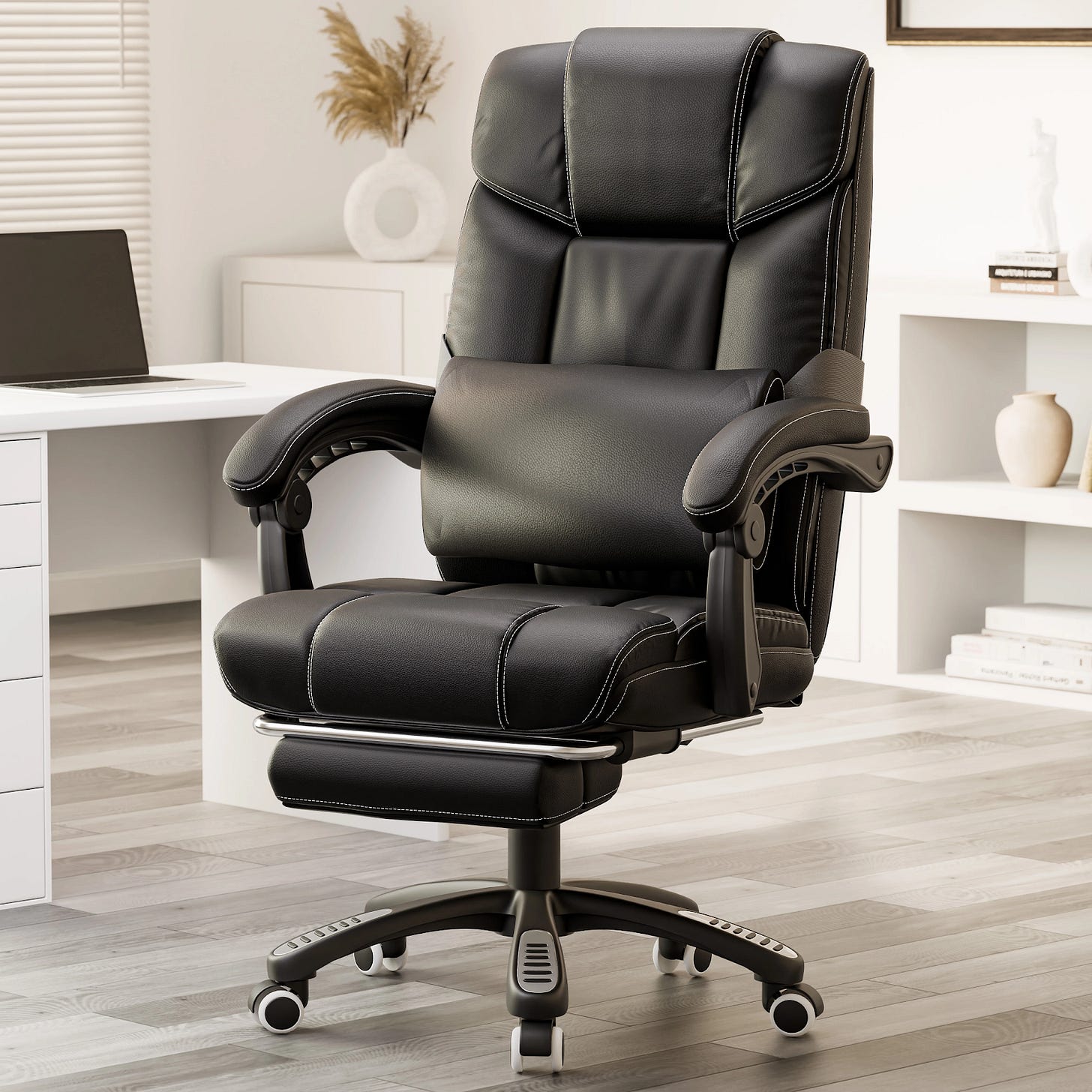  Black leather office chair with footrest and lumbar pillow near the workstation in home office