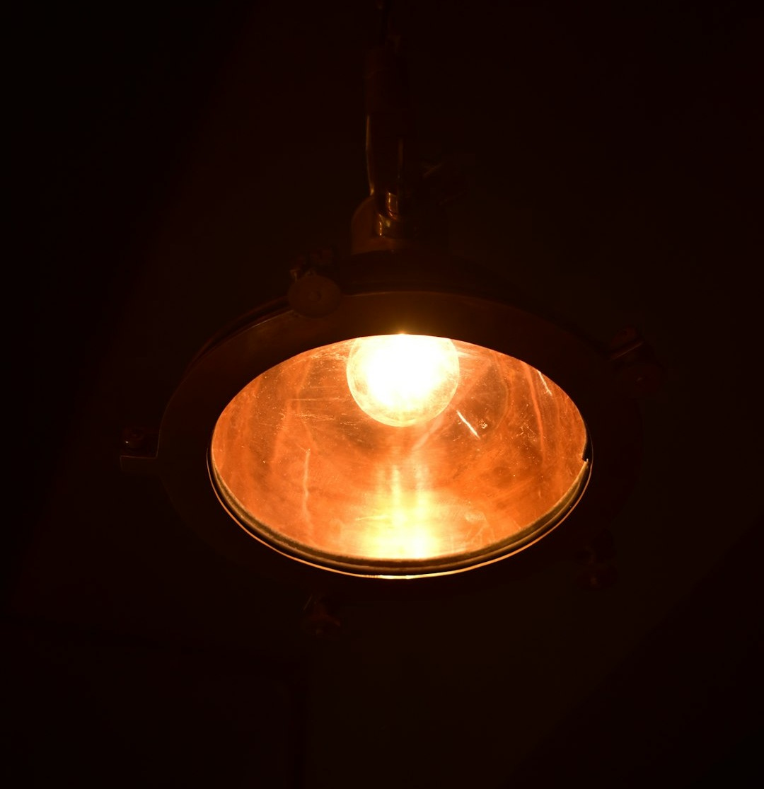 A light hanging from a ceiling in a dark room A light hanging from a ceiling in a dark room