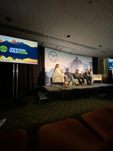 Images from Jackson Wild Summit in Grand Teton National Park in Wyoming. Graham looking through the viewfinder of a camera on a tripod. 3 people taking photos of the mountains at sunrise. 4 people sitting on stage at a Summit workshop.