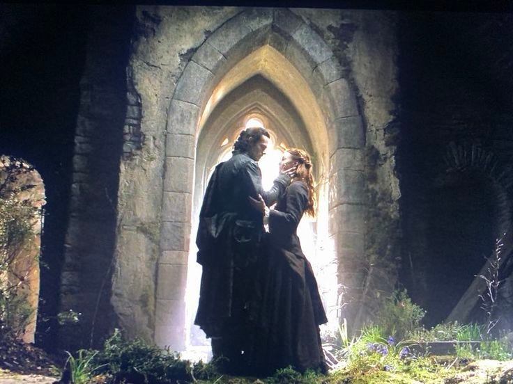 This may contain: a man and woman standing in front of an archway