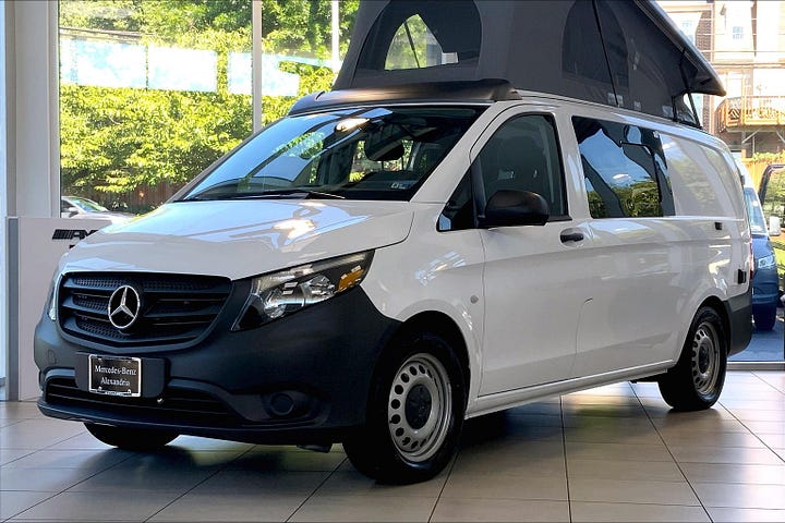 Mercedes-Benz Metris Camper Van with pop top open in the dealership showroom.