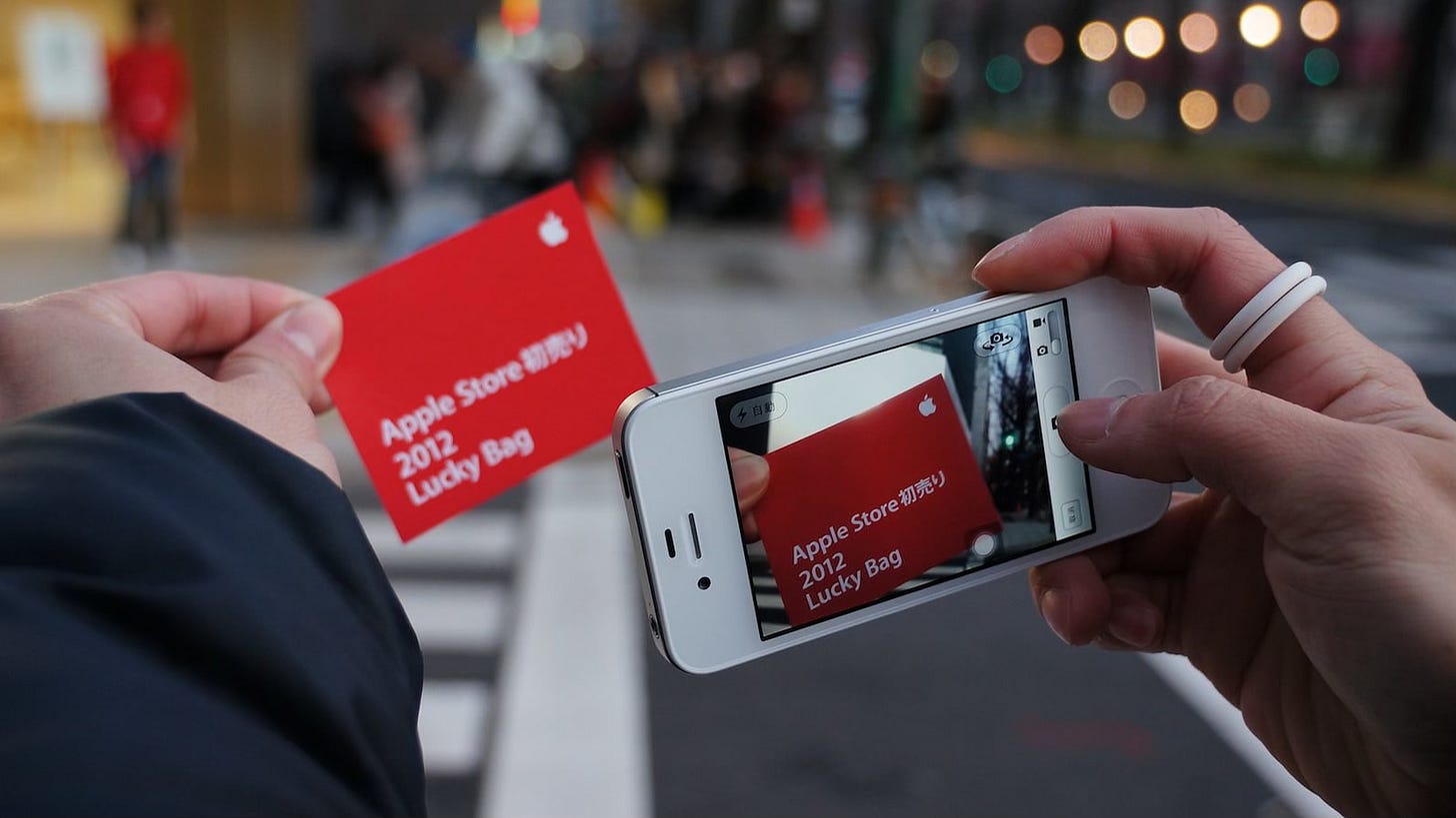 A customer takes a photo of a card that reads "Apple Store 2012 Lucky Bag" A customer takes a photo of a card that reads "Apple Store 2012 Lucky Bag"