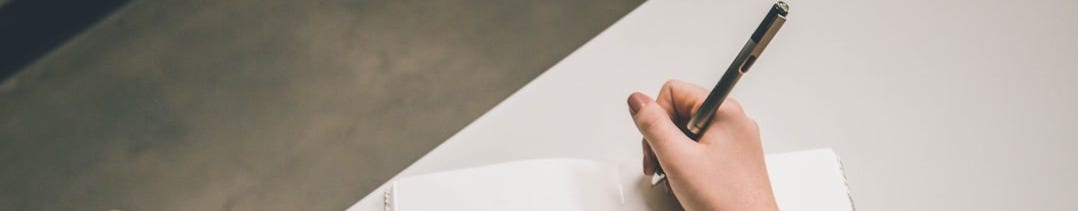 person writing on white paper person writing on white paper