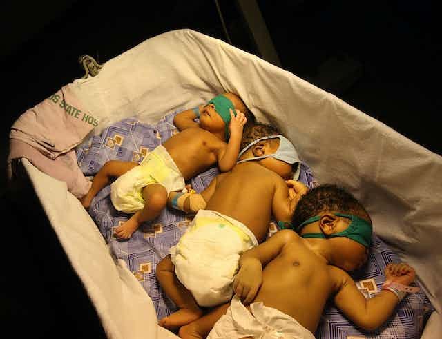 Young babies sleep together under a heat lamp at the Lagos Island Maternity Hospital, Lagos, Nigeria Young babies sleep together under a heat lamp at the Lagos Island Maternity Hospital, Lagos, Nigeria