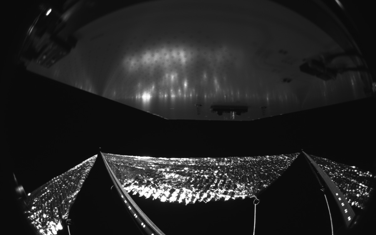 The view from one camera onboard the spacecraft shows the reflective sail quadrants supported by composite booms.