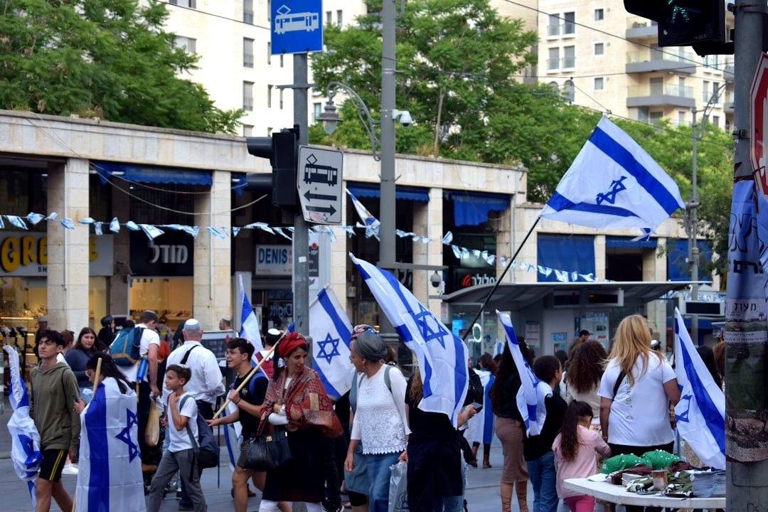 a group of people walking down a street holding flags