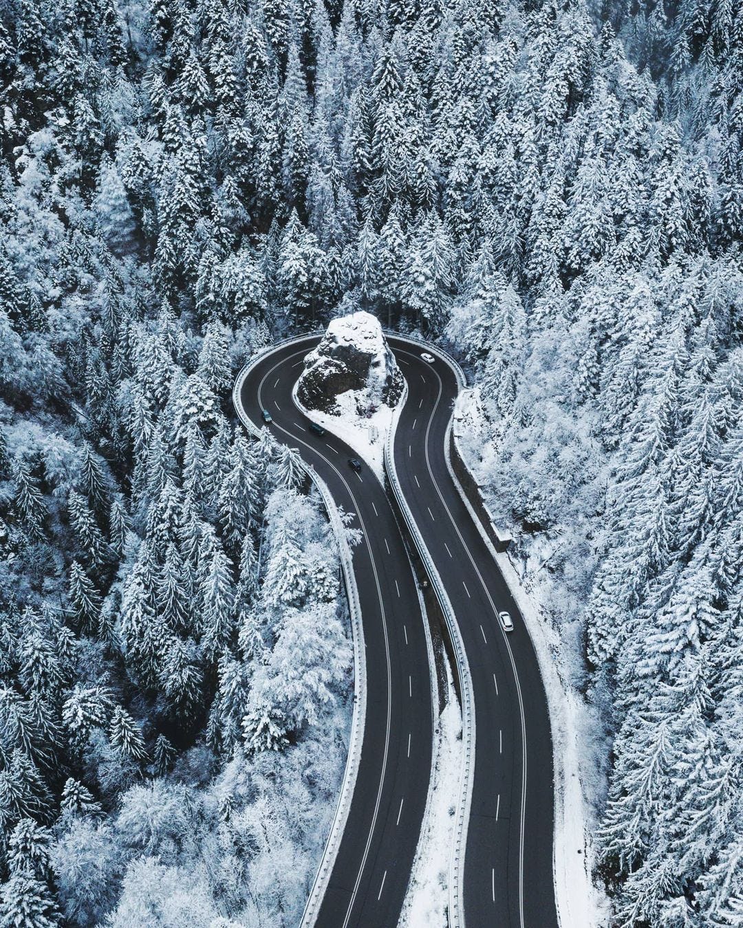 Highway in the mountains with a sharp turn around a rock