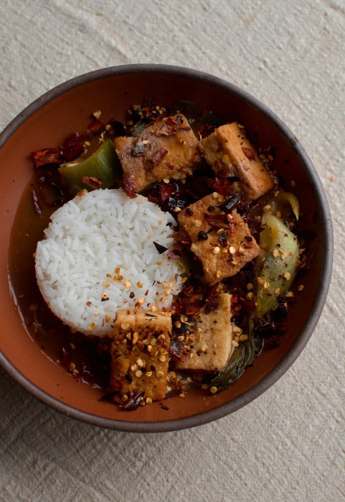 This Hunan-style tofu in hot sauce features pan-fried tofu, bok choy, leeks, and enoki mushrooms in a warm broth with plenty of spice. 