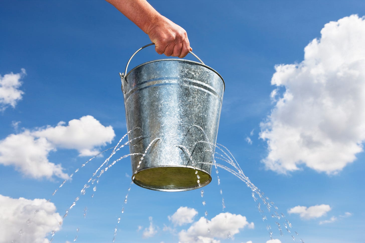 A bucket with holes leaking water A bucket with holes leaking water