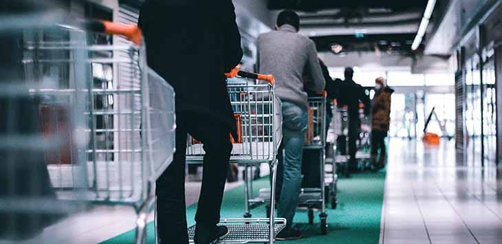 Photo of a queue of shoppers with trolleys in a supermarket