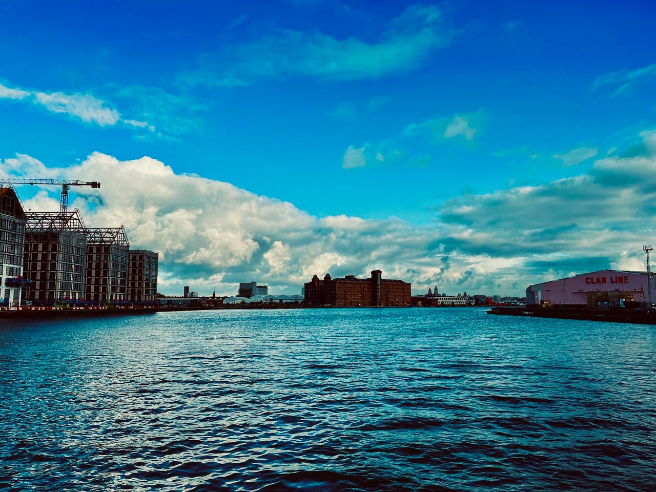 Walking across Birkenhead docks, with Liverpool beyond. 3 November 2023.