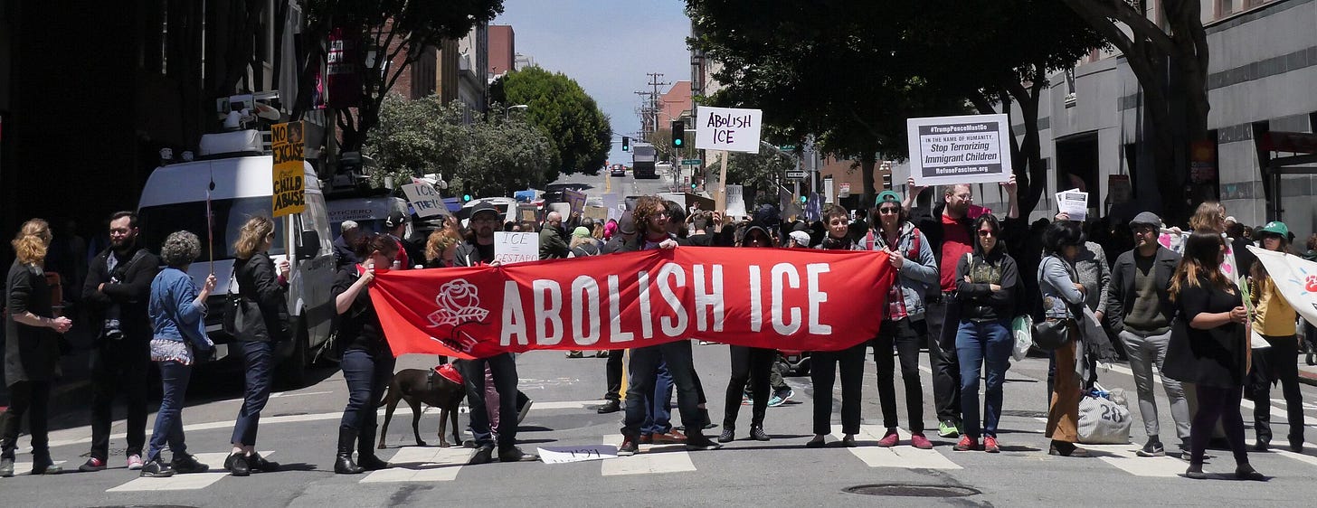 protestors holding an Abolish ICE banner protestors holding an Abolish ICE banner