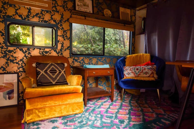 Arm chairs in wallpapered room of communal home.