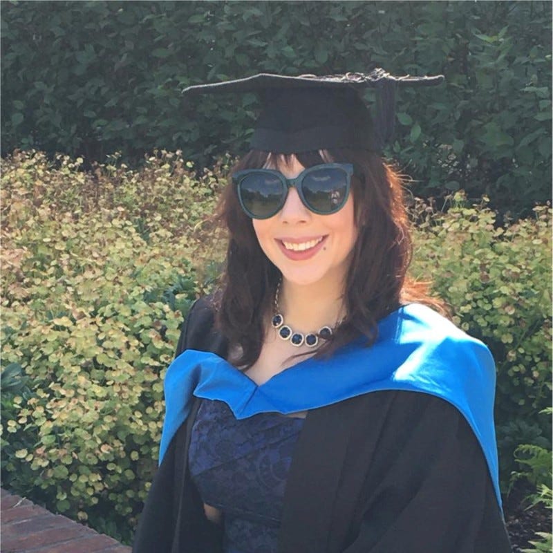 Natalie Roddis is a white woman with brown hair wearing a graduation outfit