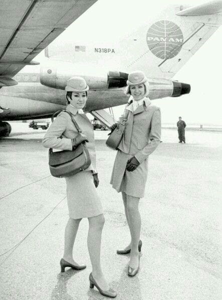 This may contain: two women are standing in front of an airplane