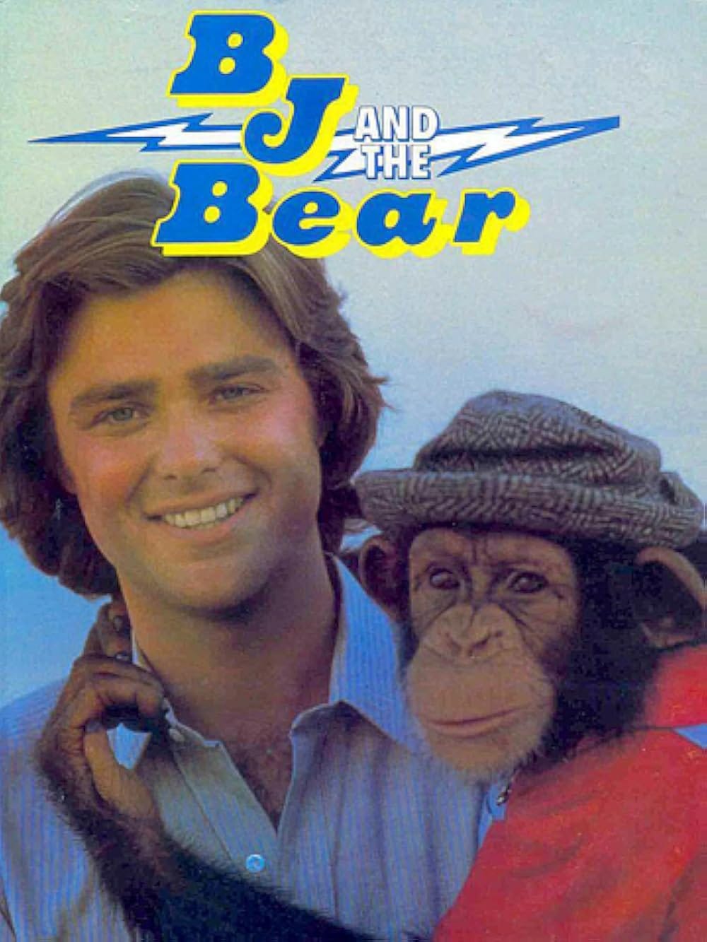A poster for the TV series BJ and the Bear featuring the actor Greg Evigan, a young man who appears to be in his late 20s and who is wearing a collared blue shirt, holding a chimp wearing a red shirt and a porkpie hat. The top of the poster has the name of the show in stylized blue and yellow text in a lightning bolt motif.