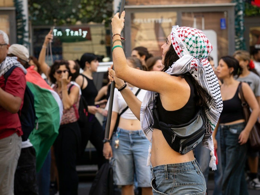 Woman waves palestinian flag at a rally