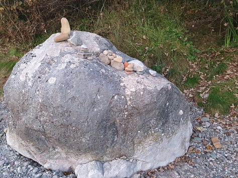 9 pictures of one large rock, each picture has different configurations of small rocks piled on top of it