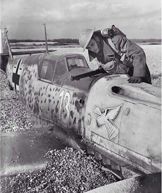 A member of Britain's Home Guard inspects a beached Bf-109, Battle of Britain, 1940.