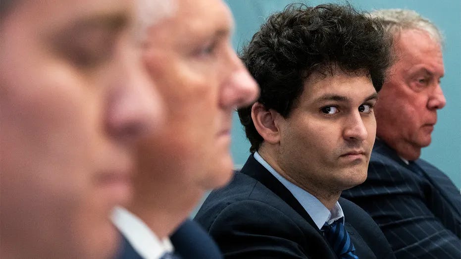 Man sitting in a hearing with others blurred in foreground, representing governance and compliance risk in startups.