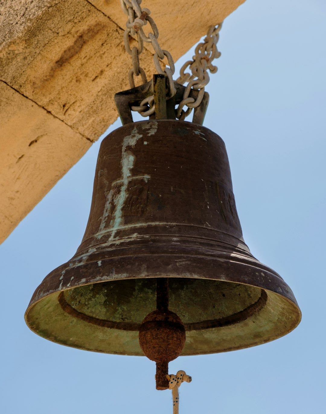a bell hanging from the side of a building a bell hanging from the side of a building