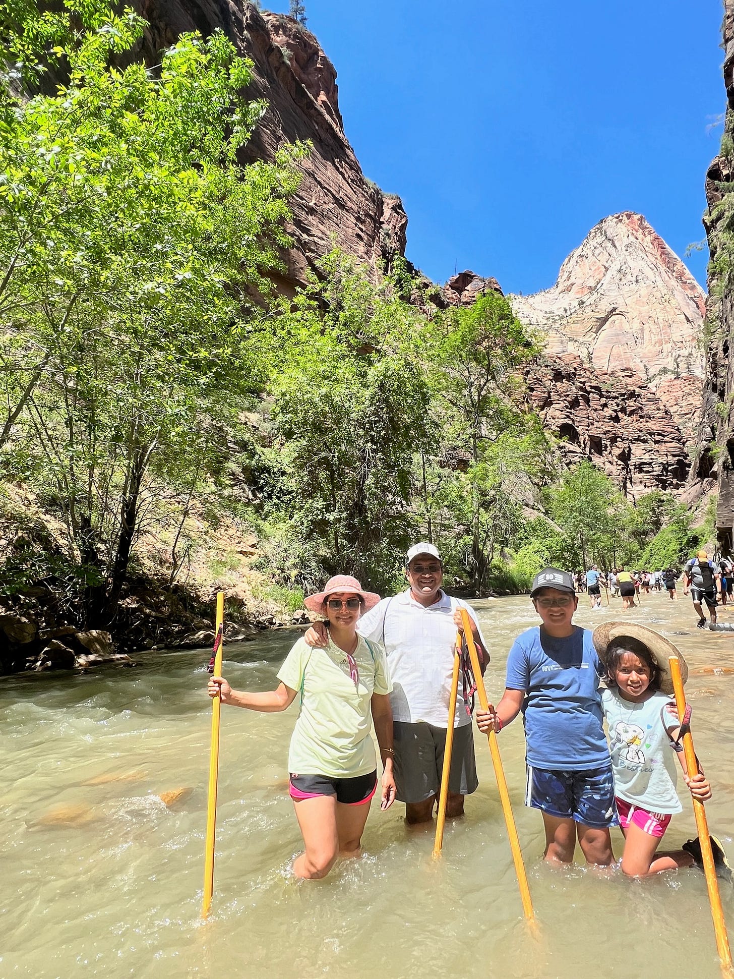 People hiking in a river canyon in the desert southwest.