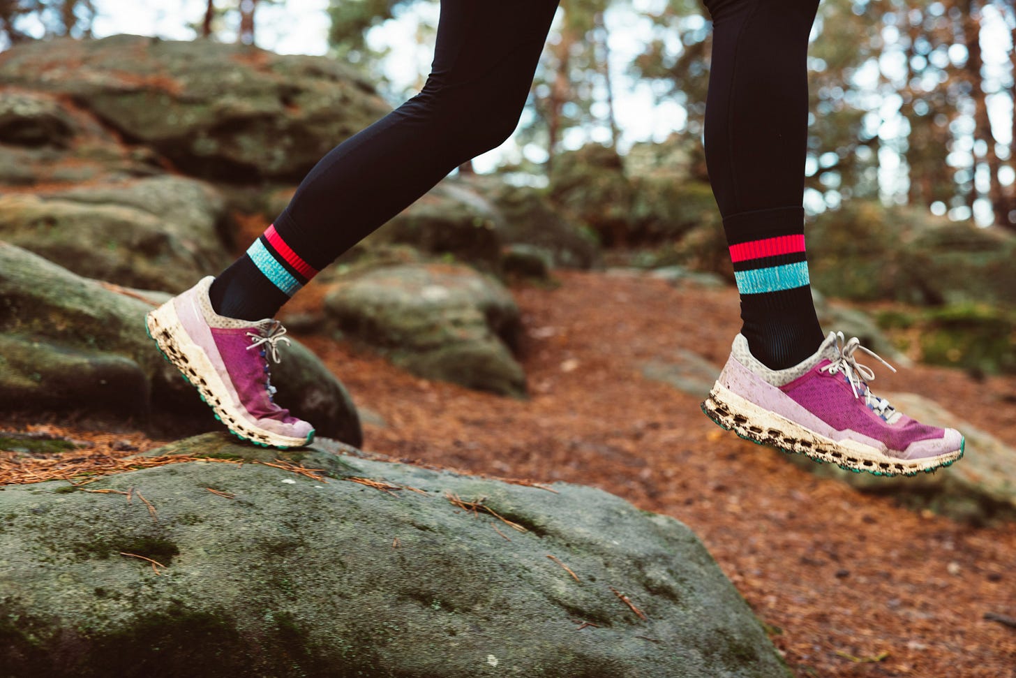 Woman trail running wearing pink sneakers