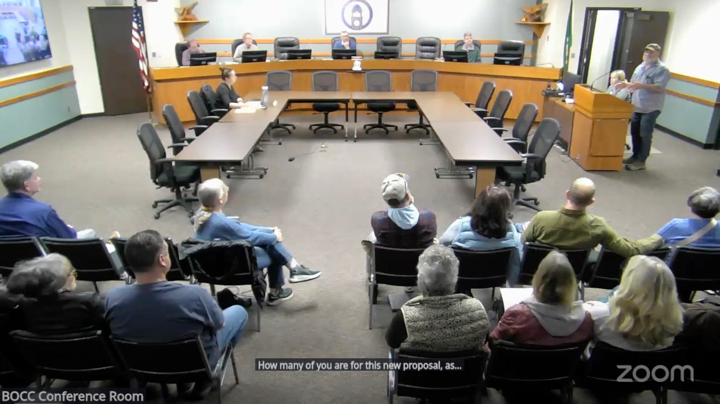 A group of people sitting in chairs in a meeting

Description automatically generated