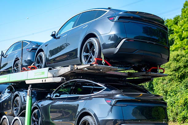 Transportanhänger mit neuen dunkelgrauen Tesla Model Y Fahrzeugen, Electric Vehicle Delivery, moderne Automobiltechnik, Autos von der Fabrik zu Händlern oder Kunden bringen, Deutschland