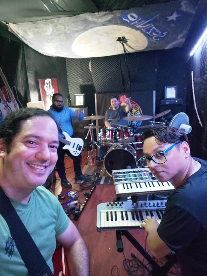 Puede ser una imagen de una o varias personas, personas de pie, guitarra e interior