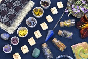 table with tarot cards, flowers, runes and crystals