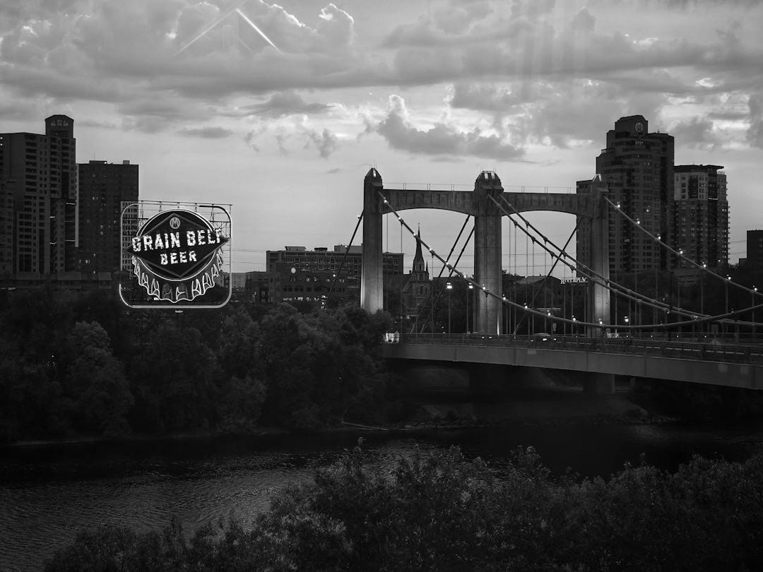 City skyline with bridge and neon beer sign at sunset. City skyline with bridge and neon beer sign at sunset.