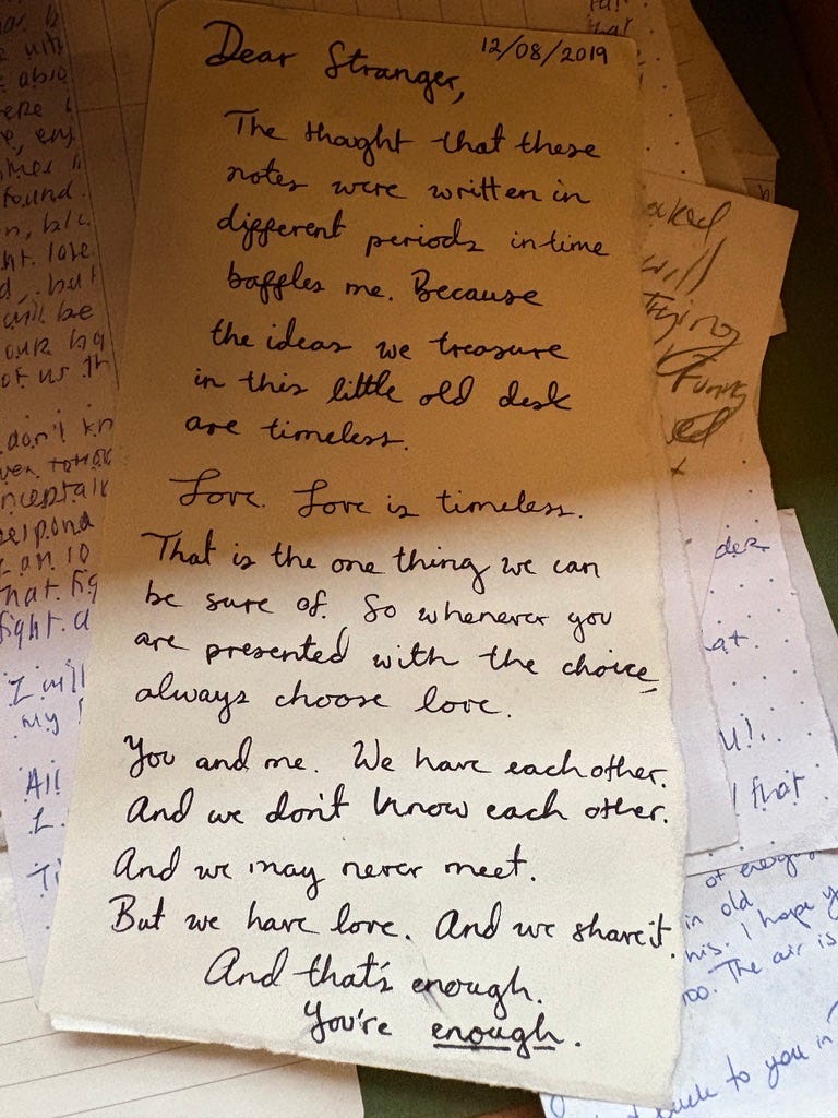 Letters in a desk drawer. The top, written in blue ink in curly handwriting, is the only fully visible letter. It reads: 12/08/2019 Dear Stranger, The thought that these notes were written in different periods in time baffles me. Because the ideas we treasure in this little old desk are timeless. Love. Love is timeless. That is the one thing we can be sure of. So whenever you are presented with the choice, always choose love. You and me. We have each other. And we don’t know each other. And we may never meet. But we have love. And we share it. And that’s enough. You’re enough. Letters in a desk drawer. The top, written in blue ink in curly handwriting, is the only fully visible letter. It reads: 12/08/2019 Dear Stranger, The thought that these notes were written in different periods in time baffles me. Because the ideas we treasure in this little old desk are timeless. Love. Love is timeless. That is the one thing we can be sure of. So whenever you are presented with the choice, always choose love. You and me. We have each other. And we don’t know each other. And we may never meet. But we have love. And we share it. And that’s enough. You’re enough.