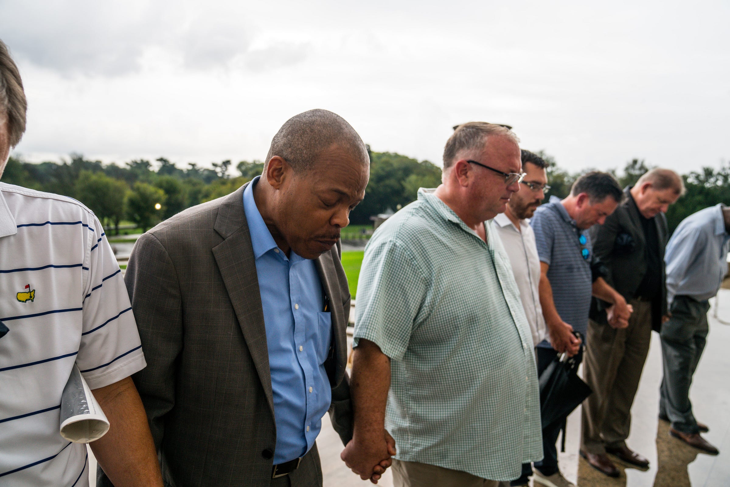 Men holding hands in a prayer group, praying Men holding hands in a prayer group, praying