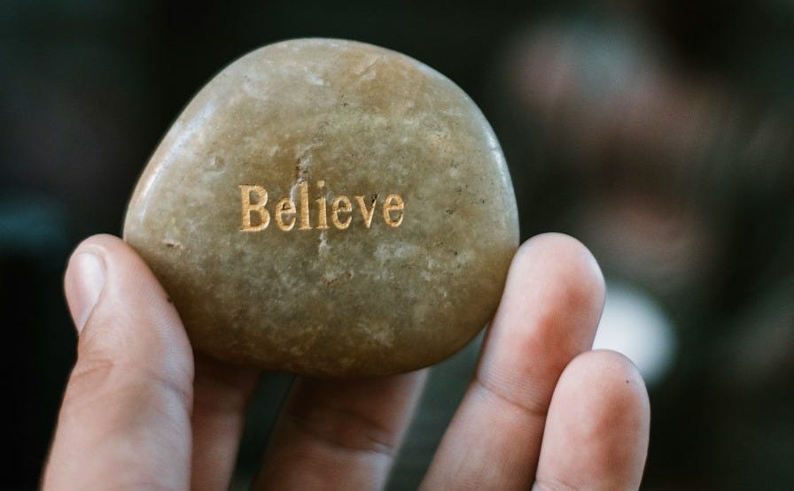 person holding brown stone with believe print person holding brown stone with believe print