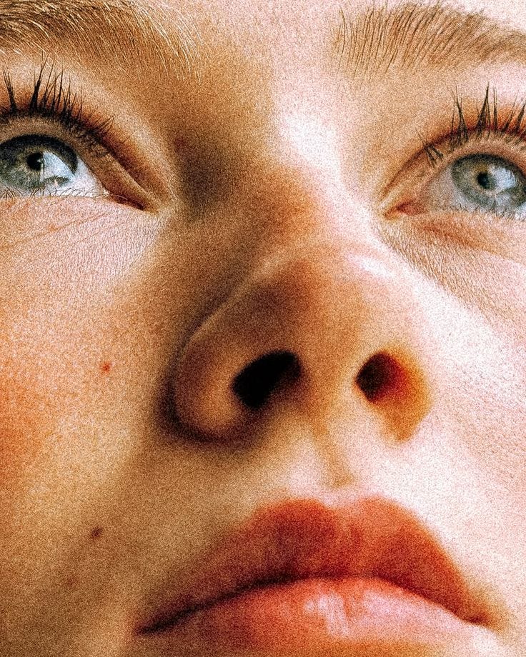 This may contain: a close up of a woman's face with blue eyes and long, straight eyelashes This may contain: a close up of a woman's face with blue eyes and long, straight eyelashes