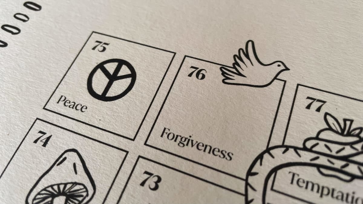 A photo of the top left of the Gyan Chaupar snakes and ladders board showing peace and forgiveness A photo of the top left of the Gyan Chaupar snakes and ladders board showing peace and forgiveness