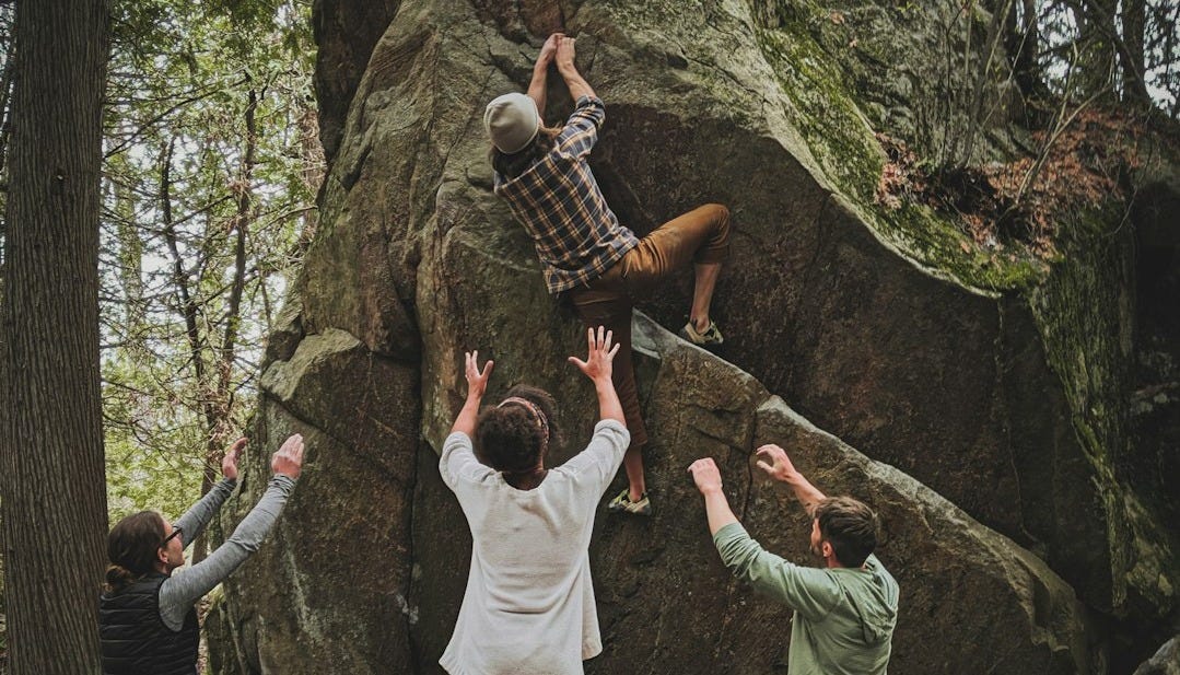 group of people in white long sleeve shirt and green pants standing on rocky ground group of people in white long sleeve shirt and green pants standing on rocky ground