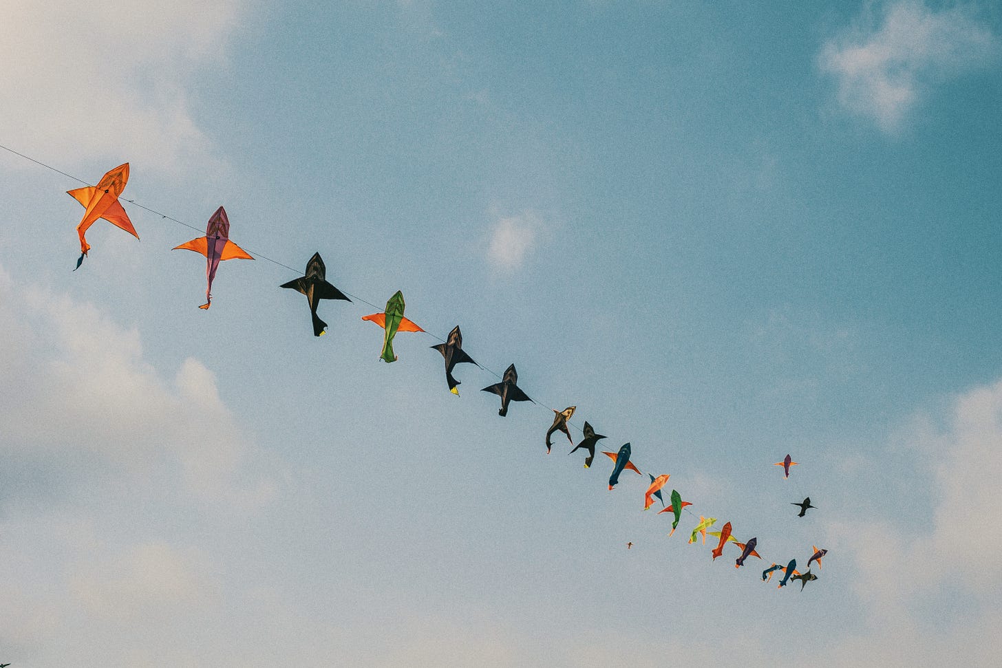 A string of fish-shaped kites floating in the sky.