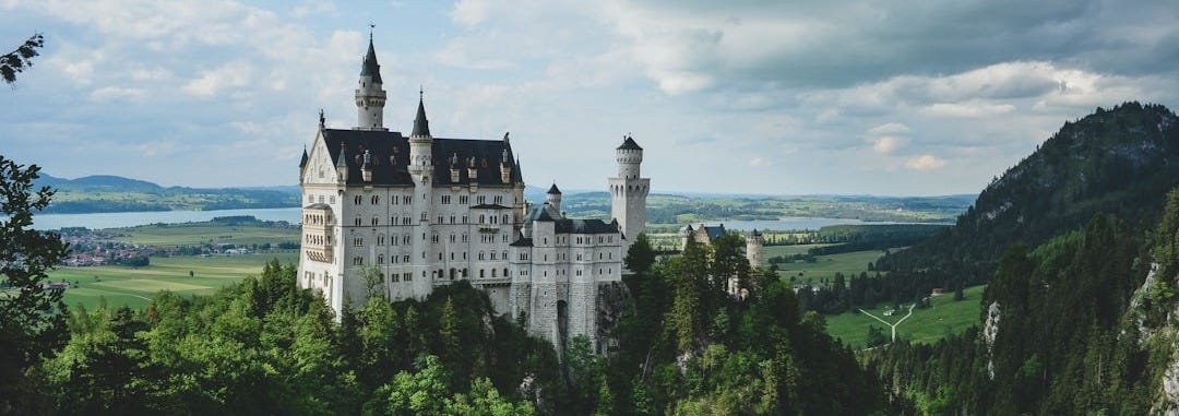 white concrete castle in green field white concrete castle in green field