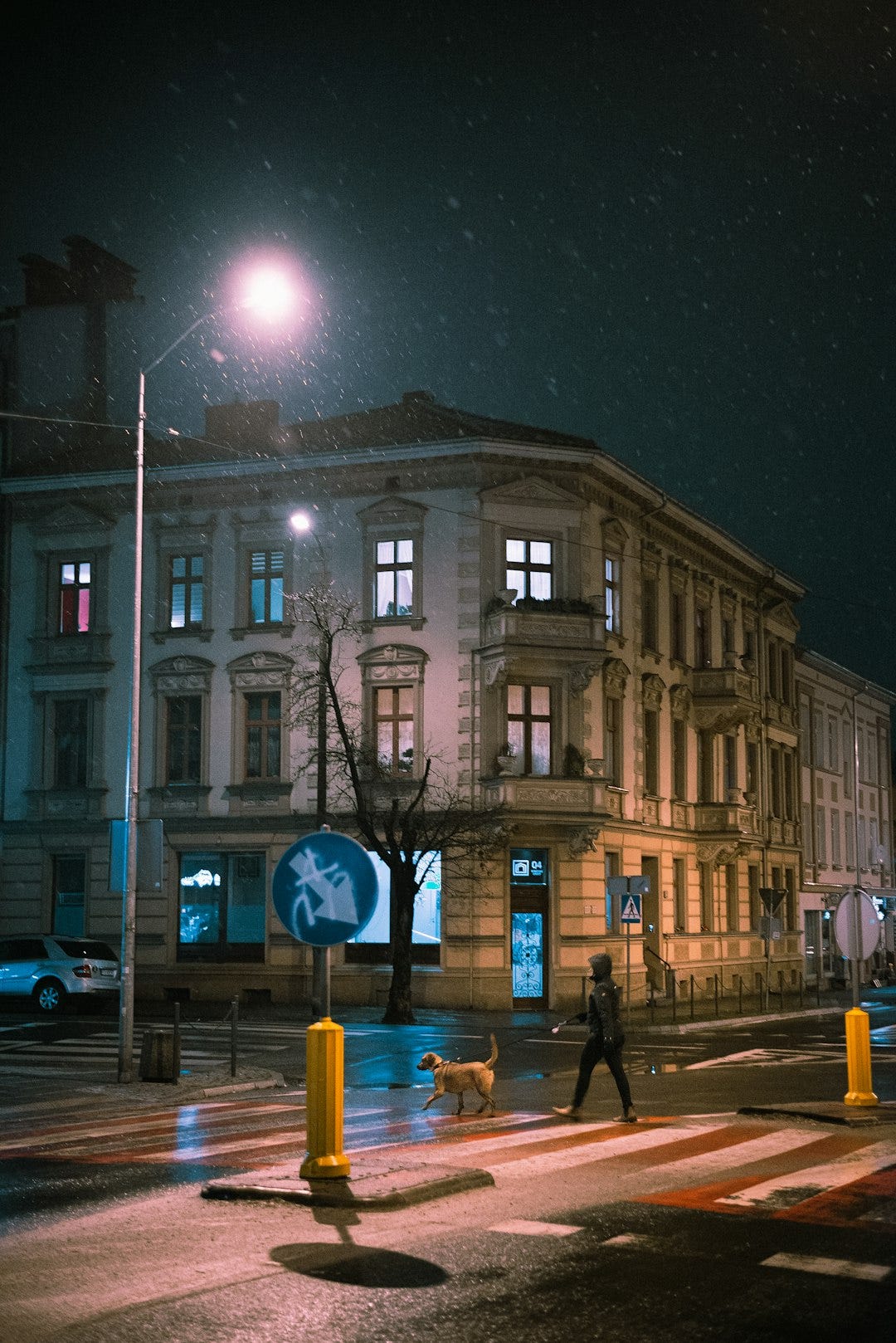 people walking on sidewalk near brown concrete building during nighttime people walking on sidewalk near brown concrete building during nighttime