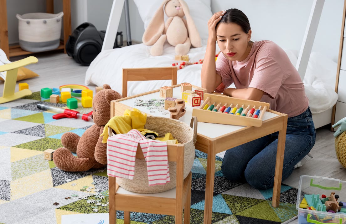 Overwhelmed woman in a messy kids rooms with toys everywhere.
