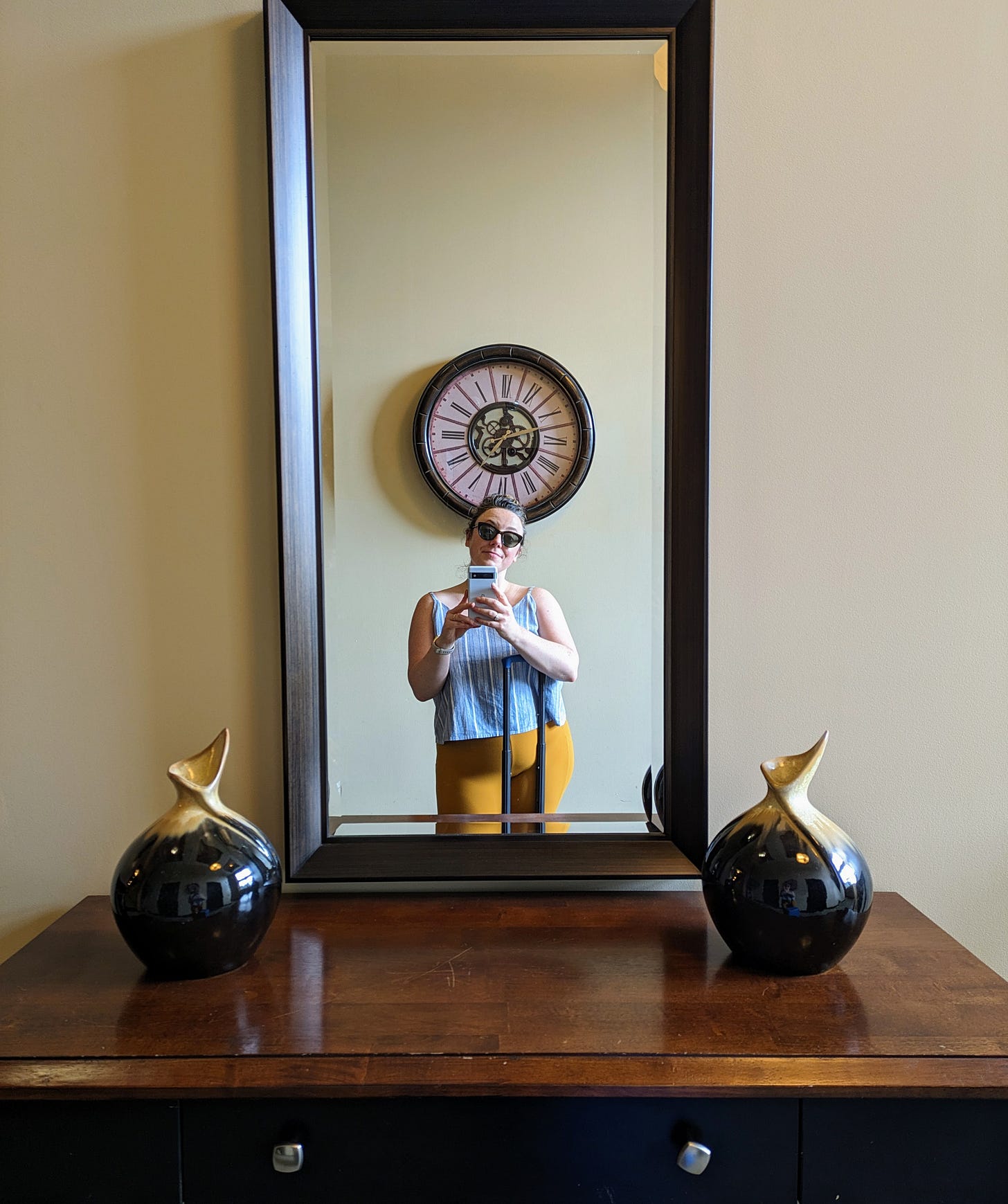 Woman lookin in a mirror at a clock. Woman lookin in a mirror at a clock.