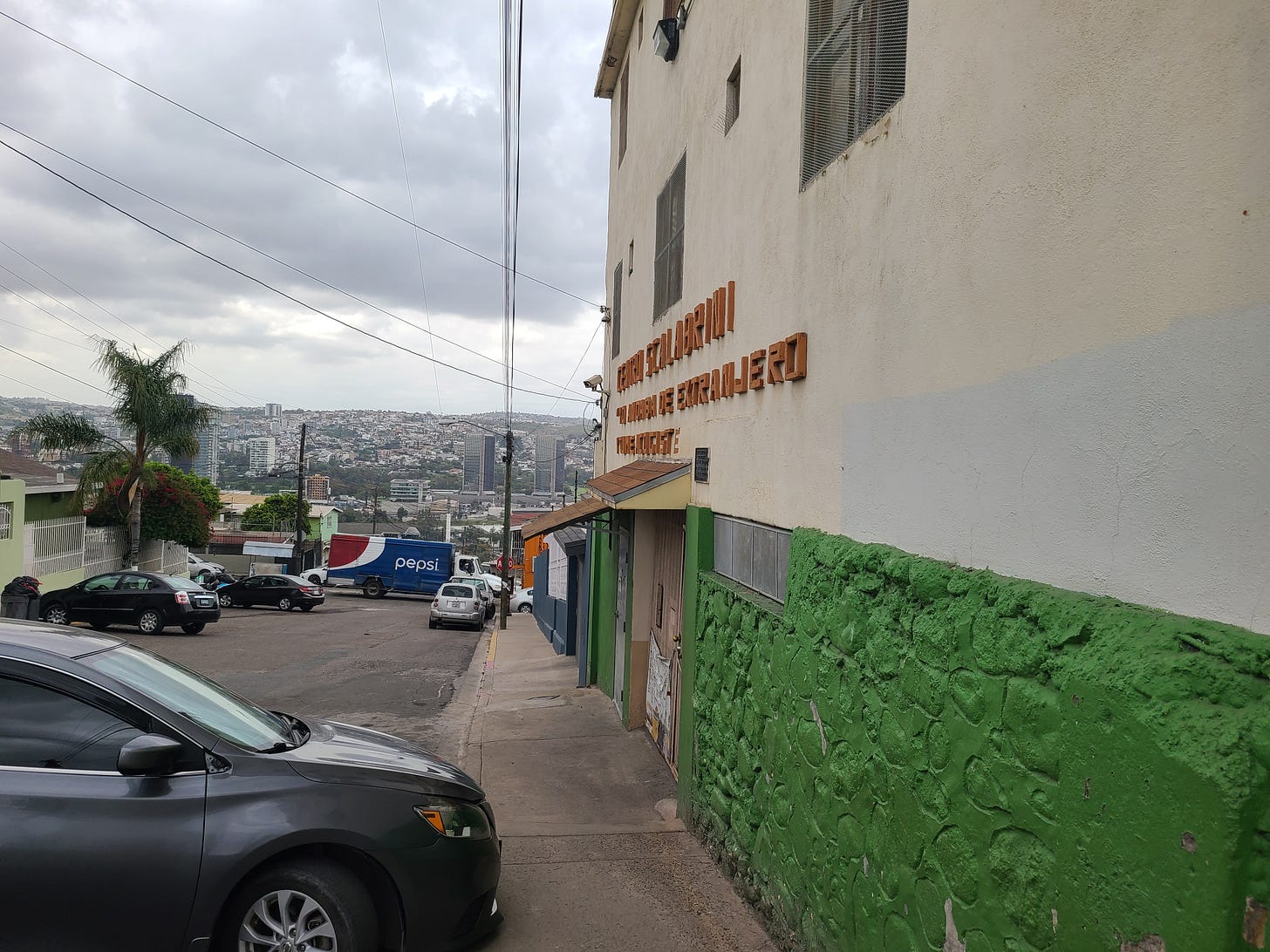 The exterior of Casa del Migrante is green and tan