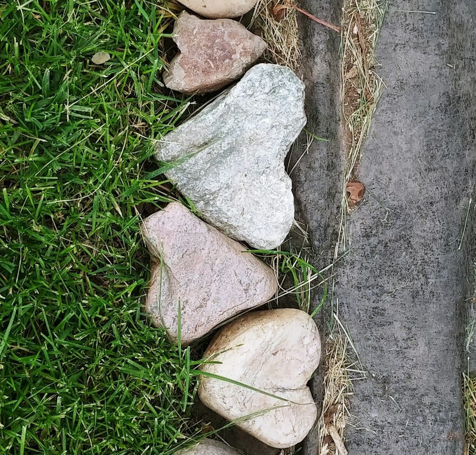 rock hearts on grass path