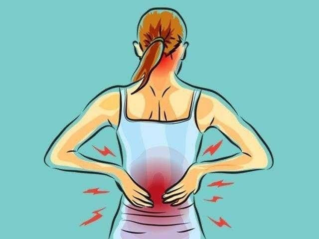 This may contain: a woman with back pain holding her hands on her hips and looking at the ground